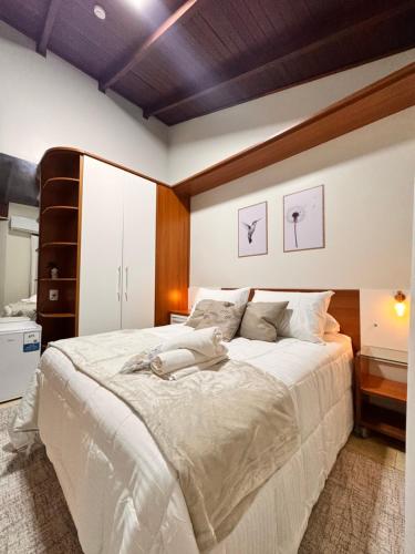 a bedroom with a large bed with white sheets at Pousada Vivenza - Suíte 03 e 04 in Laguna