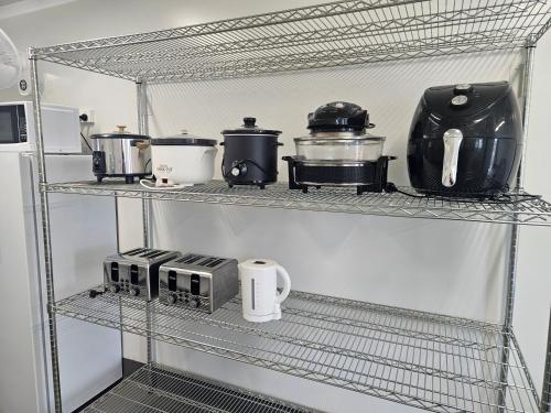 a kitchen shelf with various appliances on it at AAOK Riverdale Caravan Park in Bundaberg