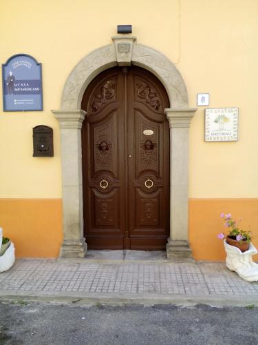 a large wooden door on the side of a building at La Casa dellAmericano - Casa d'epoca anni '30 in Aliano