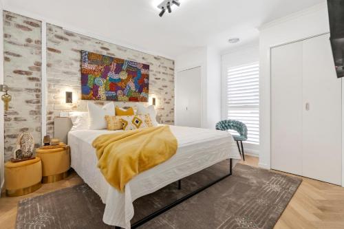 a bedroom with a bed with a yellow blanket on it at Apollo Bay Gone Surfin in Apollo Bay