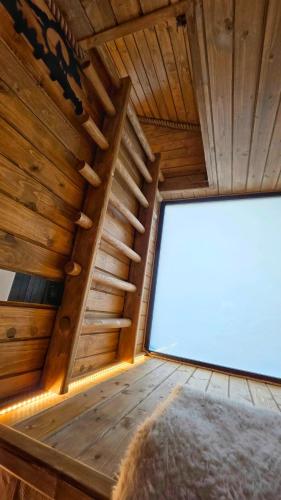 a large window in the ceiling of a wooden cabin at Casuta de la munte in Sărişor