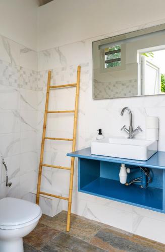a bathroom with a sink and a toilet at Villa Caryota, Panorama Montagnes & Piscine 9m in Le Marin