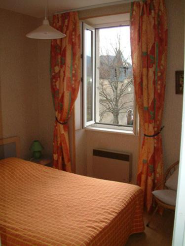 une chambre avec un lit et une fenêtre dans l'établissement Gîtes des Gabriels, à La Chapelle-en-Vercors