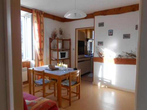 Il comprend un salon avec une table et une cuisine équipée d'un réfrigérateur. dans l'établissement Gîtes des Gabriels, à La Chapelle-en-Vercors