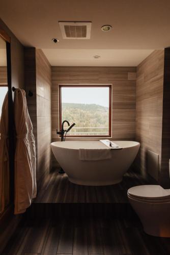 a bathroom with a tub and a toilet and a window at Salish Lodge & Spa in Snoqualmie