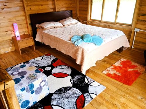 a bedroom with a bed and two rugs on the floor at Cabañas Sumak Kawsay in Colón