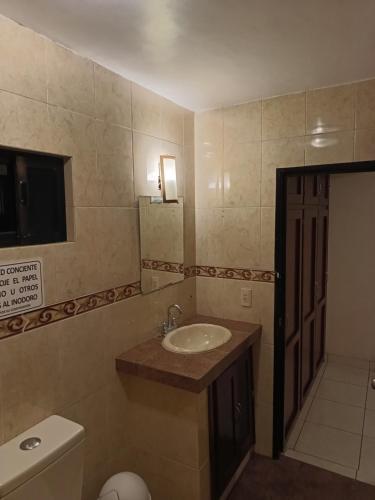 a bathroom with a sink and a toilet and a mirror at Hotel Tropigalas in Tampamachoco