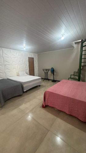 a bedroom with two beds and a table in it at Casa pôr do Sol in Aracaju