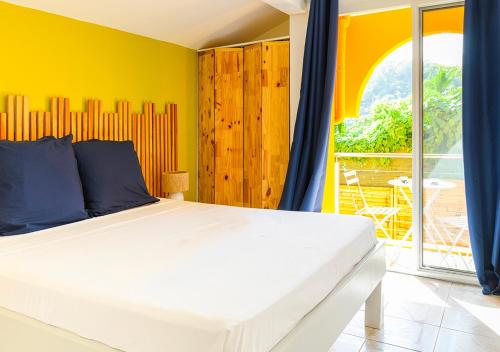 a bedroom with a large bed and a balcony at Villa Caryota, Panorama Montagnes & Piscine 9m in Le Marin