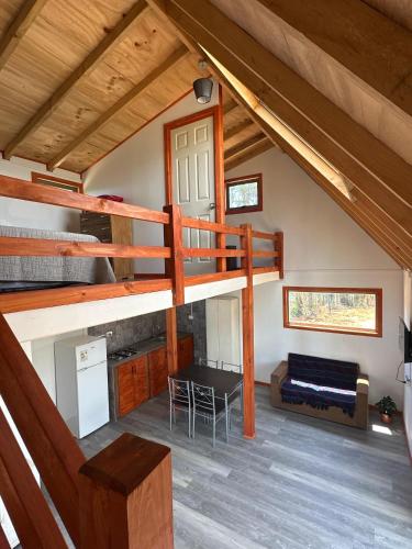 a loft bed in a cabin with a living room at CIRyT La Montaña - Eco Cabañas y Turismo Rural in Tomé