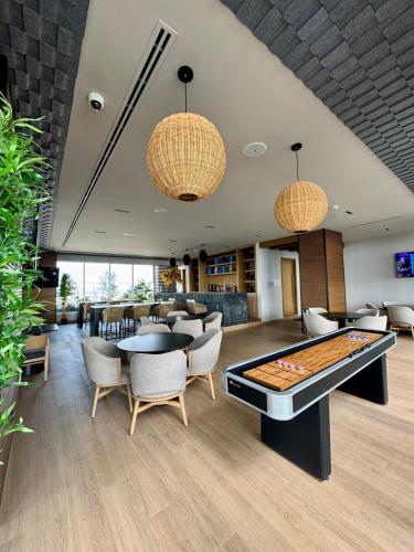 a room with a pool table and chairs at Modern Apartment Pool & Gym by Paseo Santa Lucía in Monterrey