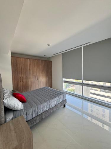 a bedroom with a bed and a large window at Modern Apartment Pool & Gym by Paseo Santa Lucía in Monterrey
