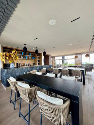 a restaurant with tables and chairs in a room at Modern Apartment Pool & Gym by Paseo Santa Lucía in Monterrey