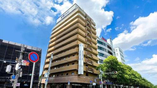 a tall building with a sign on the side of it at Toyoko Inn Hanshin Amagasaki Ekimae in Amagasaki