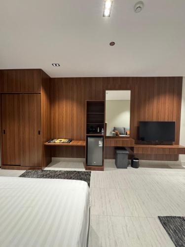 a bedroom with a bed and a tv and a mirror at فندق وفود فرع القريات in Al Qurayyat