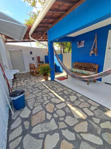 a patio with a hammock on a house at Pousada Odoyá Beach - Quádrupla in Conde