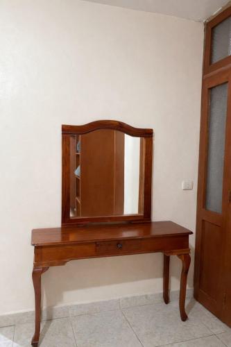 a wooden table with a mirror on a wall at Hotel Real de Juarez in Xalapa