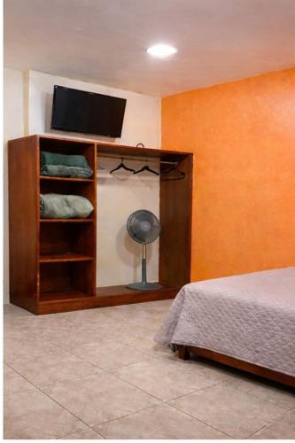 a room with a bed and a tv on a wall at Hotel Real de Juarez in Xalapa