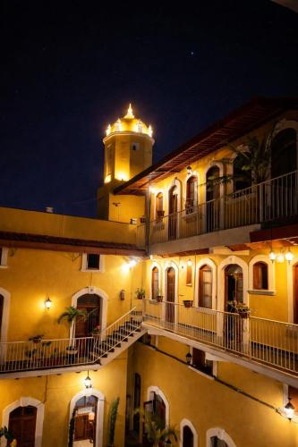 a building with a clock tower on top of it at night at Hotel Real de Juarez in Xalapa