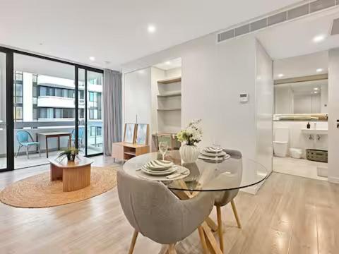 a dining room with a glass table and chairs at Prime Location for an Event in Olympic Park in Sydney