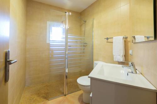 ein Badezimmer mit Dusche, Toilette und Waschbecken in der Unterkunft Short De Son Fideu in El Estanyol