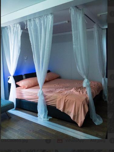 a bed with white drapes in a bedroom at Villa Gregorio mountain top in Bonao