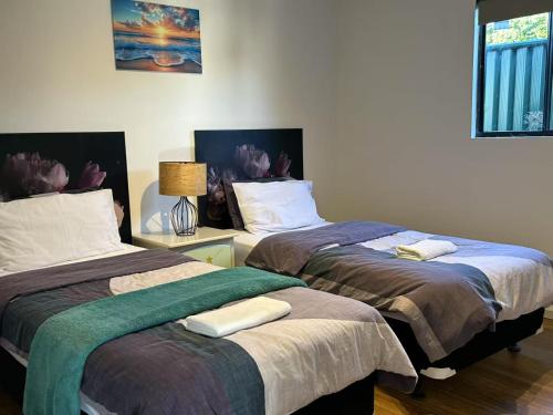 two beds sitting next to each other in a room at Cosy and convenient accommodation in Springvale