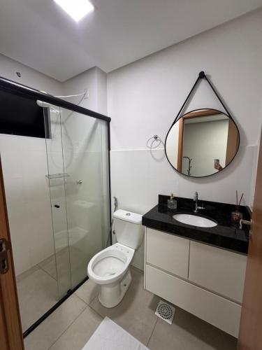 a bathroom with a toilet and a sink and a mirror at Studio em Anápolis in Anápolis