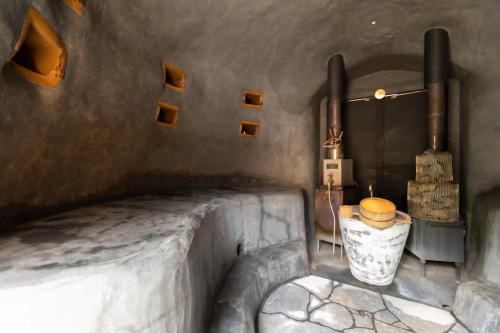 a room with a bath tub with a stove at サ郷 kakeRu 新旧アースバッグサウナ付 in Onna