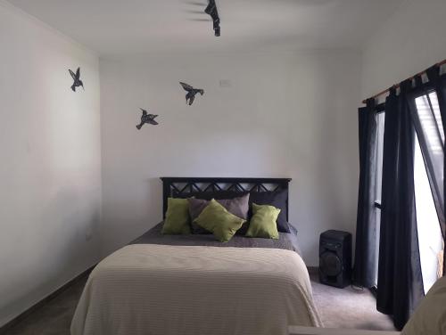 a bedroom with a bed with green pillows at Lo de Mili in General Juan Madariaga