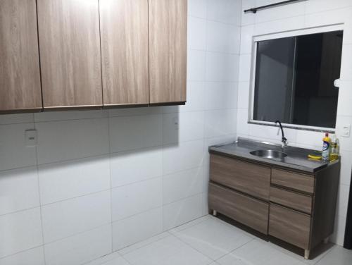 a bathroom with a sink and a window at Casa inteira in Ponta Grossa