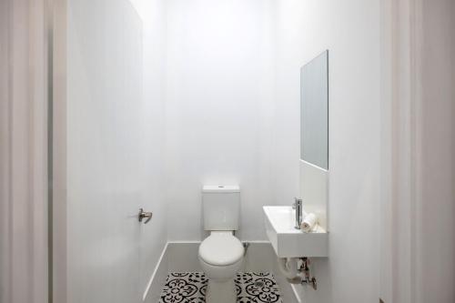 a white bathroom with a toilet and a sink at 1 Duke street in Albany