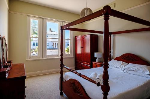 a bedroom with a canopy bed with a dog laying on it at 1 Duke street in Albany