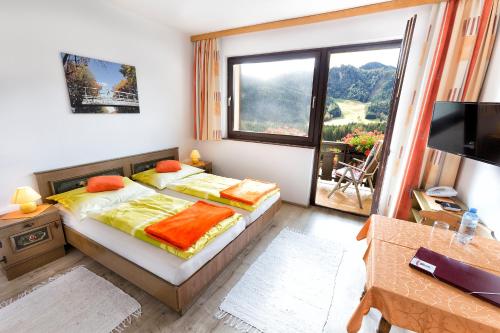 1 dormitorio con 2 camas y ventana grande en Bed&Breakfast Lausegger en Ferlach