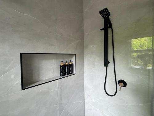 a shower in a bathroom with a black shower head at Taratara retreat in Kaeo