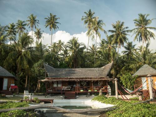 a resort with a swimming pool and palm trees at Simeulue Surflodges in Lasikin