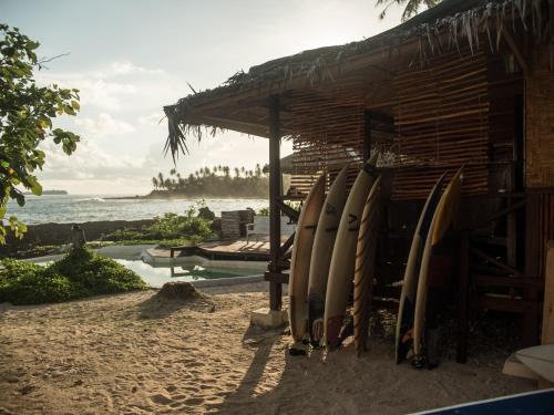 a bunch of surfboards leaning against a building on the beach at Simeulue Surflodges in Lasikin