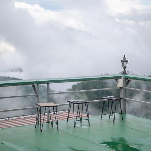 two chairs and a lamp on a deck with a view at MonLanna Homesty in Ban Thung Pa Haeo
