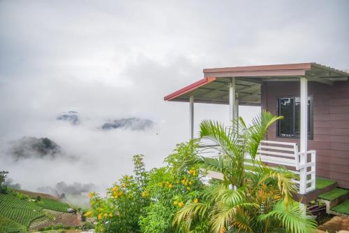 a house on a hill with clouds in the background at MonLanna Homesty in Ban Thung Pa Haeo