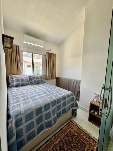 a small bedroom with a bed and a window at Studio 12 in Santa Cruz Cabrália