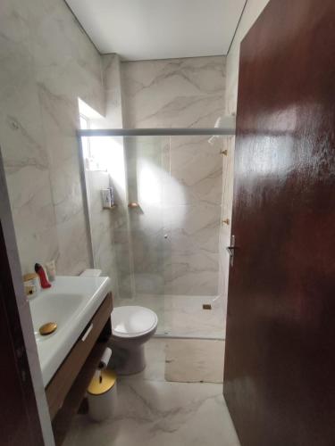 a bathroom with a shower and a toilet and a sink at JK Beach Club Bar e Pousada in Ibiúna