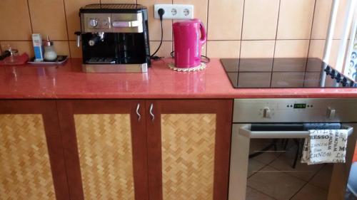 a kitchen with a red counter top with a coffee maker at Liget Apartman in Budapest