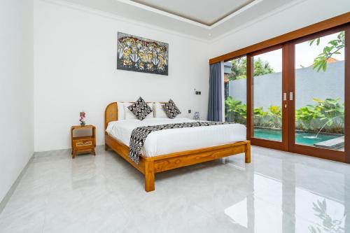 a bedroom with a bed and a large window at Made Ubud Villa by Bali Cabin in Ubud
