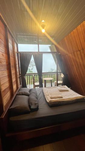 a large bed in a room with a window at Padangsari Cabin 2 in Diyeng
