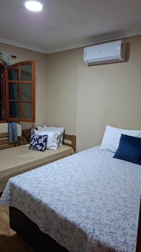 a bedroom with two beds and a window at Casa do sossego in Cabo Frio