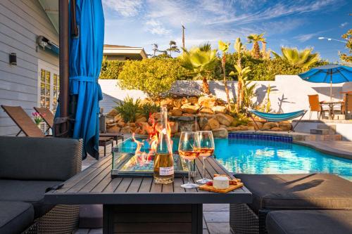 a table with two glasses of wine next to a swimming pool at Stunning View Estate with Pool & Game Room in La Mesa