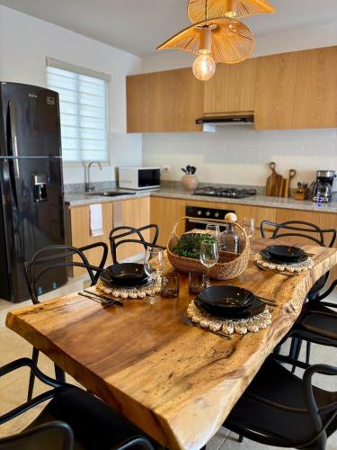 a wooden table with plates and glasses on it in a kitchen at Boutique loft Cholula-Pue area Design and comfort in Cholula