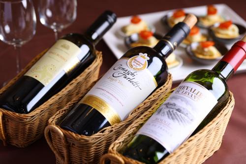 three bottles of wine in baskets on a table at Hotel Takimoto in Yamanouchi