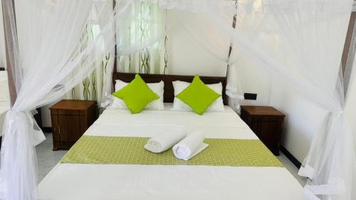 a bedroom with a bed with two towels on it at Paddy Wind Eco Lodge Sigiriya in Kibissa