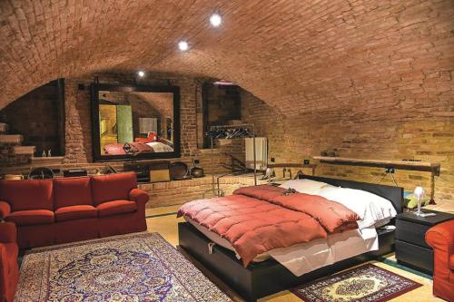 マントヴァにあるカーサ ムゼオ パラッツォ ヴァレンティ ゴンザーガのレンガの壁、ベッド付きのベッドルーム1室